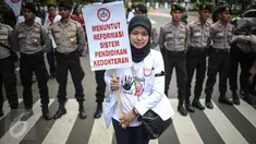 Seorang dokter membawa poster saat melakukan aksi unjuk rasa di Ibu Kota hari ini, Senin (24/10). Demo itu untuk menuntut pemerintah agar membatalkan Program Dokter Layanan Primer (DLP). (Liputan6.com/Faizal Fanani)
