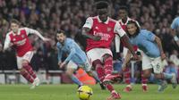 Gelandang Arsenal, Bukayo Saka menembak untuk mencetak gol dari titik penalti ke gawang Manchester City selama pertandingan lanjutan Liga Inggris di stadion Emirates di London, Inggris, Kamis (16/2/2023). Hasil ini membuat Man City menggeser Arsenal di puncak klasemen. (AP Photo/Kin Cheung )