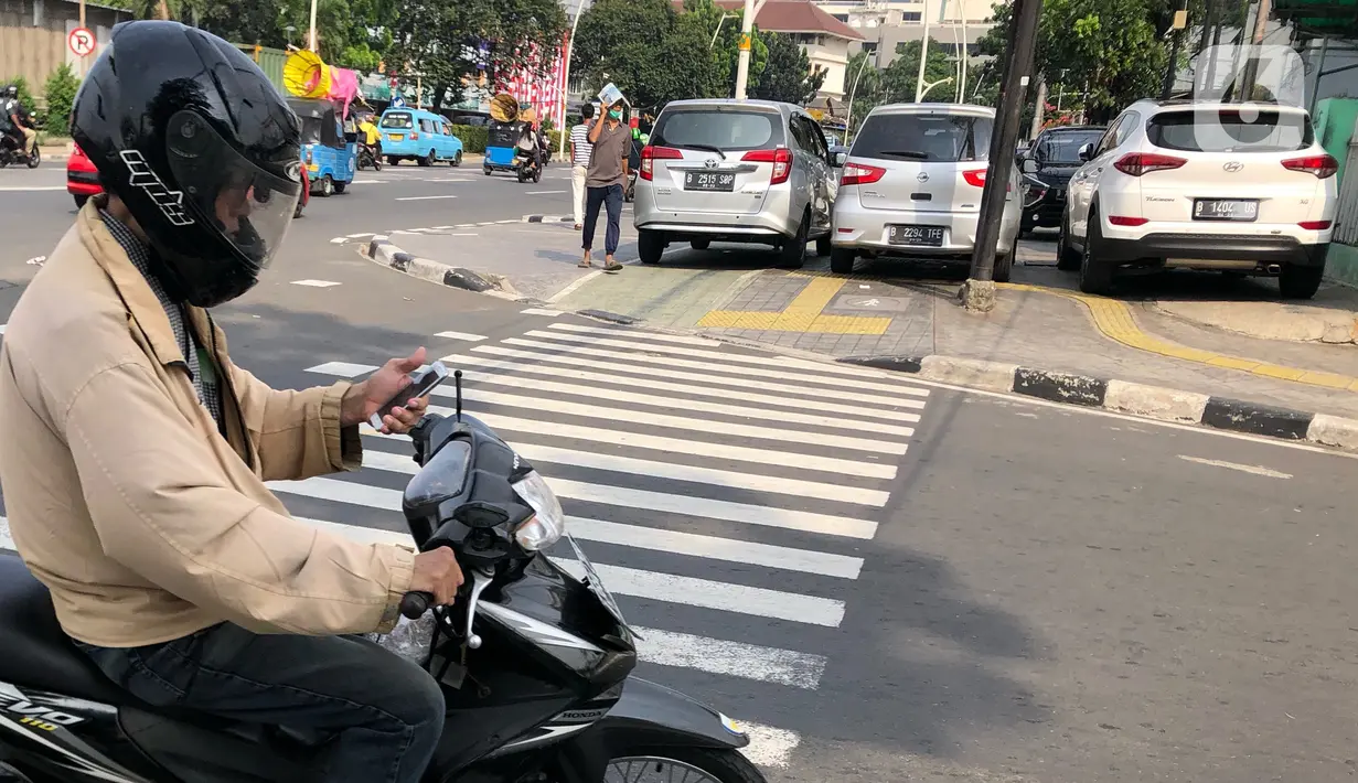 Kendaraan terparkir di sekitar trotoar kawasan Jatinegara, Jakarta, Selasa (14/7/2020). Tidak adanya sanksi tegas membuat trotoar yang telah diperlebar tersebut justru dimanfaatkan sebagai lahan parkir liar yang mengganggu ketertiban umum. (Liputan6.com/Immanuel Antonius)