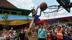 Gubernur DKI Jakarta Basuki T Purnama membantu seorang bocah memasukkan bola ke dalam ring basket seusai meresmikan Ruang Publik Terpadu Ramah Anak (RPTRA) Intiland Teduh, Karet Tengsin, Jakarta, Rabu (30/12). (Liputan6.com/Yoppy Renato)