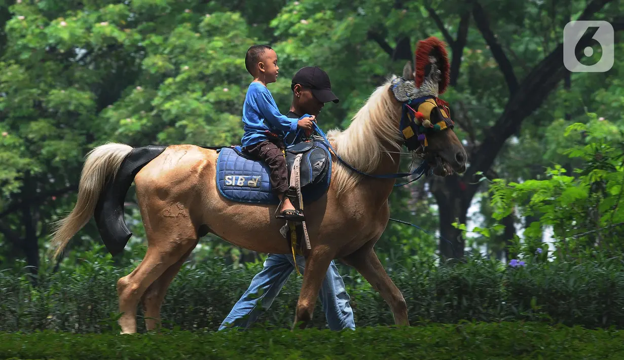 Seorang anak menunggang kuda di Kawasan Kanal Banjir Timur, Jakarta, Kamis (11/4/2024). (merdeka.com/Imam Buhori)