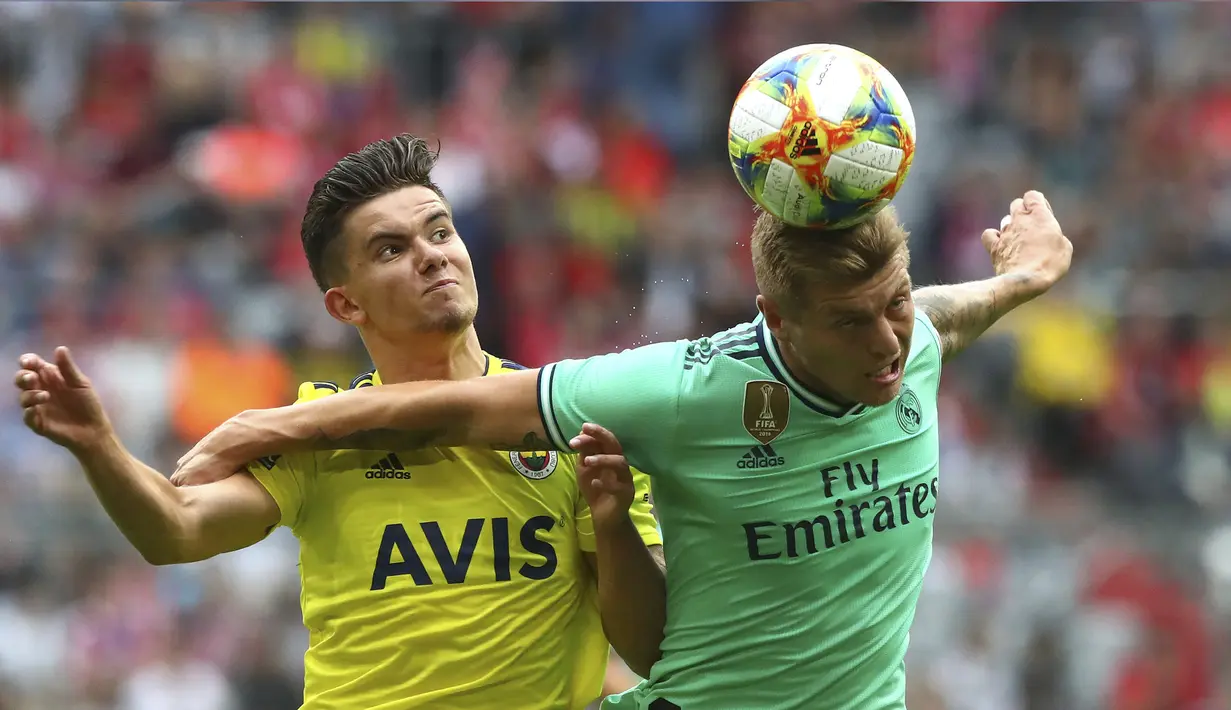 Gelandang Real Madrid, Toni Kroos berebut bola udara dengan pemain Fenerbahce, Ferdi Kadioglu selama pertandingan Audi Cup 2019 di stadion Allianz Arena di Munich, Jerman (31/7/2019). Madrid menempati posisi ketiga di Audi Cup 2019. (AP Photo/Matthias Schrader)