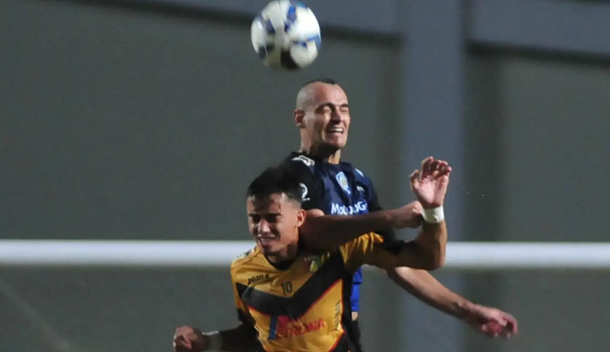Bek Arema Cronus, Kiko Insa, duel udara dengan pemain Mitra Kukar pada laga leg pertama semifinal Piala Jenderal Sudirman. (Bola.com/Kevin Setiawan)