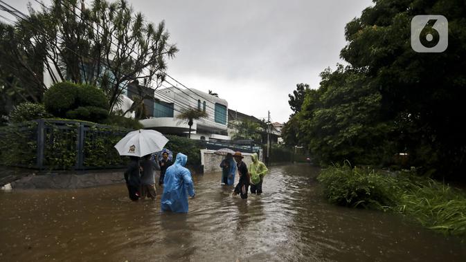 Warga beraktivitas diarea lingkungannya yang tergenang banjir di Jalan Hang Lekir, Kebayoran Lama, Jakarta Selatan, Rabu (1/1/2020). Banjir tersebut disebabkan karena tingginya intensitas hujan yang mengguyur sejak Selasa (31/12/2019). (Liputan6.com/Johan Tallo)