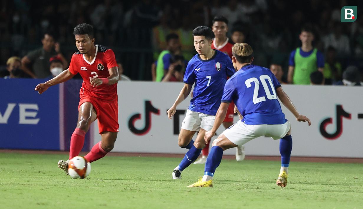<p>Bek Timnas Indonesia U-22, Amiruddin Bagas Kaffa menguasai bola di depan dua pemain Kamboja pada laga keempat Grup A SEA Games 2023 di Olympic National Stadium, Phnom Penh, Kamboja, Rabu (10/5/2023). (Bola.com/Abdul Aziz)</p>