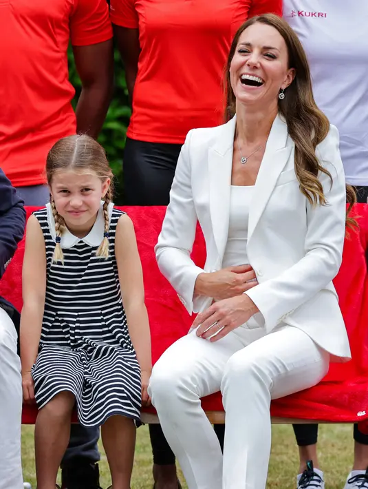 Duke dan Duchess of Cambridge Kate Middleton dan dan Putri Charlotte (kiri) berpose untuk difoto selama kunjungan ke SportsAid House pada hari kelima Commonwealth Games di Birmingham, Inggris tengah (2/8/2022). Ibu tiga anak ini tampil trendi dalam setelan celana putih Alexander McQueen seharga £1.945 untuk acara tersebut, yang pertama kali ia kenakan selama tur Karibia awal tahun ini. (AFP/Pool/Chris Jackson)