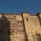 Sebuah kereta kuda melintas di depan Masjid Katedral Cordoba di kota Cordoba, Spanyol, 26 September 2018. Bangunan yang dikenal dengan Mezquita de Cordoba ini sekarang beralih fungsi menjadi gereja katedral untuk umat Katolik. (AFP/JORGE GUERRERO)