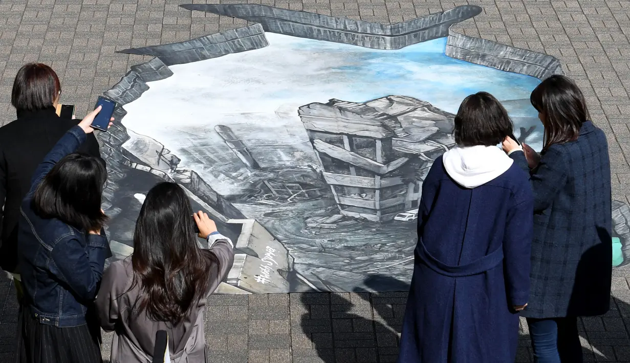 Sejumlah warga melihat sebuah karya ilusi optik 3-D yang bergambar kota Aleppo yang hancur akibat perang di kampus Universitas Meiji di Tokyo, Jepang (18/11). Karya ini ditampilkan untuk menimbulkan rasa kemanusiaan di Jepang. (AFP/Toshifumi Kitamura)