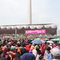 Suasana saat warga antre untuk mendapatkan sembako gratis dalam acara "Untukmu Indonesia" di lapangan Monas, Jakarta, Sabtu (28/4). Selain itu acara juga dimeriahkan dengan doa lintas agama, dan pembagian sembako. (Liputan6.com/Arya Manggala)