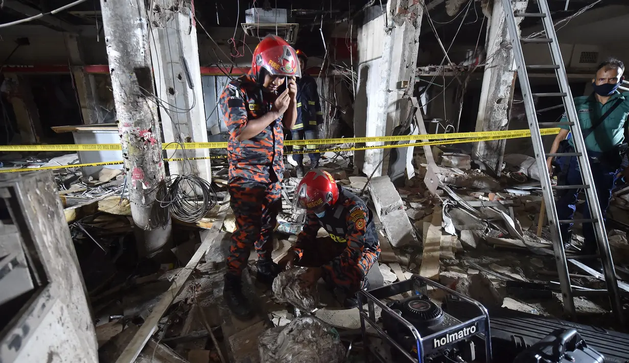 Petugas damkar memeriksa tempat kejadian setelah dugaan ledakan gas di jalanan ramai di Moghbazar, Dhaka, Bangladesh, Minggu (27/6/2021). Setidaknya tujuh orang tewas dan lebih dari 50 lainnya terluka dalam ledakan yang terjadi di lantai bawah gedung tiga lantai tersebut. (Munir Uz zaman/AFP)