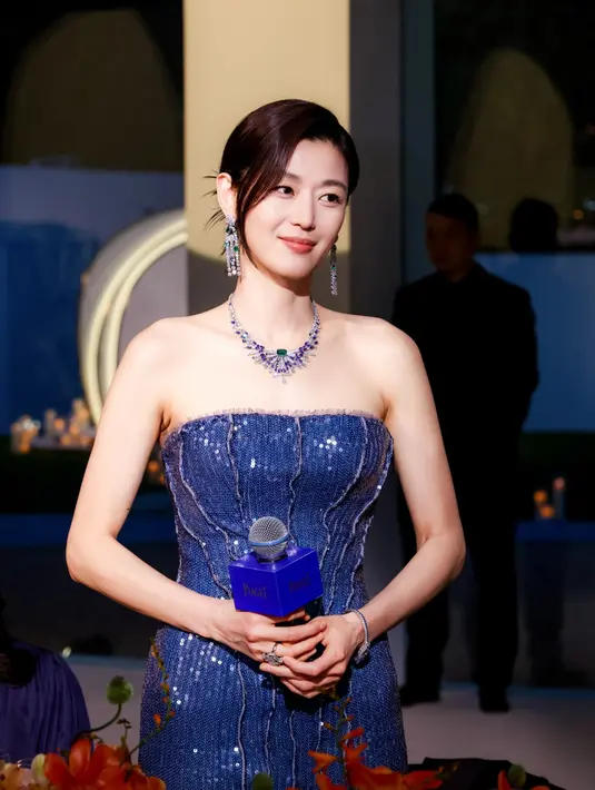 Sementara pada tampilan lainnya, Gianna Jun menjelma bak ratu malam dalam gaun sequined biru gelap yang memeluk tubuh dengan siluet mermaid.  [Dok/Piaget].