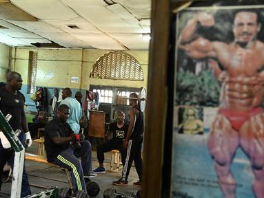 Sejumlah binaragawan mengangkat beban saat berolahraga di gym Kaloleni, di Nairobi, Kenya (9/1). (AFP Photo/Simon Maina)