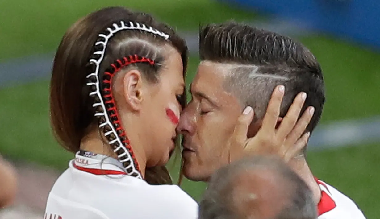 Bintang timnas Polandia, Robert Lewandowski dihibur istrinya seusai dikalahkan Senegal pada pertandingan pertamanya di Piala Dunia 2018 di Stadion Spartak, Moskow, Selasa (19/6). Polandia dikalahkan Senegal 1-2 pada penyisihan grup H. (AP/Themba Hadebe)