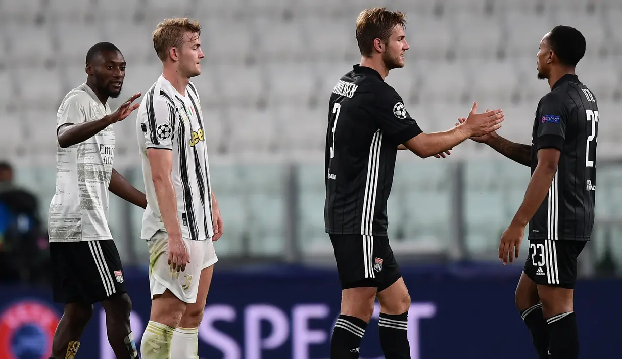 Pemain Olympique Lyon, Kenny Tete dan Joachim Andersen, merayakan kemenangan agregat dari Juventus pada laga leg kedua Liga Champions 2019/2020 di Stadion Allianz, Sabtu (8/8/2020) dini hari WIB. Juventus kalah agregat 2-2 atas Olympique Lyon. (AFP/Miguel Medina)
