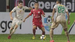 Pemain Persija Jakarta, Riko Simanjuntak (tengah) mencoba melewati adangan pemain Persebaya pada laga Gojek Liag 1 bersama Bukalapak di Stadion PTIK, Jakarta (26/6/2018). Persija dan Persebaya bermain imbang 1-1. (Bola.com/Nick Hanoatubun)