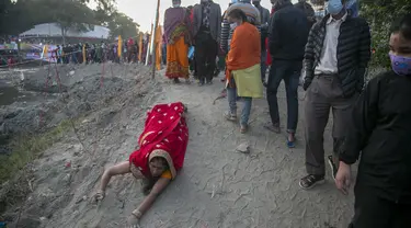 Seorang umat Hindu Nepal berbaring sujud, sebagai bagian dari ritual, di tepi Sungai Bagmati selama festival Chhath Puja di Kathmandu, Nepal, Rabu (10/11/2021). Selama Chhath, sebuah festival Hindu kuno, ritual dilakukan untuk terima kasih kepada Dewa Matahari. (AP Photo/Niranjan Shrestha)