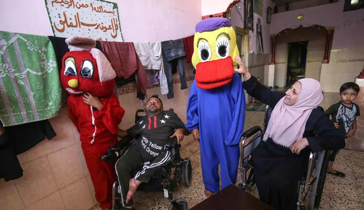 Nihad Jarboa (37) dan istrinya Zeinab (35), warga Palestina yang hidup dengan cacat fisik sejak masa kanak-kanak, duduk di kursi roda ketika klien mencoba kostum kartun yang mereka buat, di rumah mereka di kamp pengungsi Rafah di Gaza selatan Telanjangi, pada 19 Juli 2020. (AFP Photo/Said Khatib)
