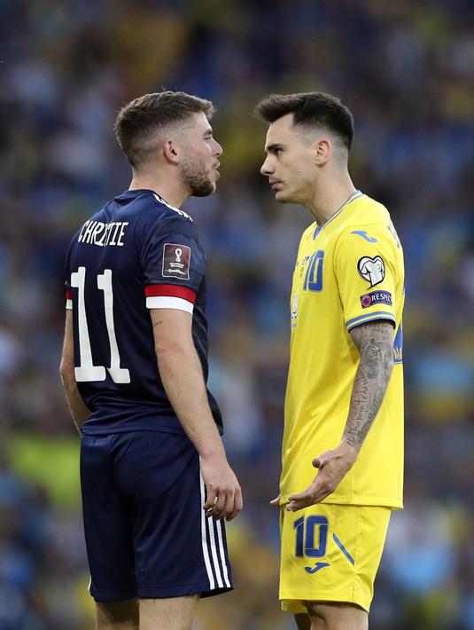 Pemain Skotlandia Ryan Christie (kiri) berdiskusi dengan pemain Ukraina Mykola Shaparenko pada pertandingan play-off kualifikasi Piala Dunia 2022 di Hampden Park Stadium, Glasgow, Skotlandia, 1 Juni 2022. Ukraina menang 3-1. (AP Photo/Scott Heppell)