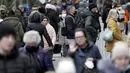 Orang-orang antre di depan sebuah toko sementara yang lain memadati jalan perbelanjaan di Berlin, Jerman, Selasa (21/12/2021). Jerman akan memutuskan pembatasan baru, yang kemungkinan dilakukan setelah Natal, yang bertujuan memperlambat penyebaran Covid-19 varian baru omicron (AP Photo/Michael Sohn)