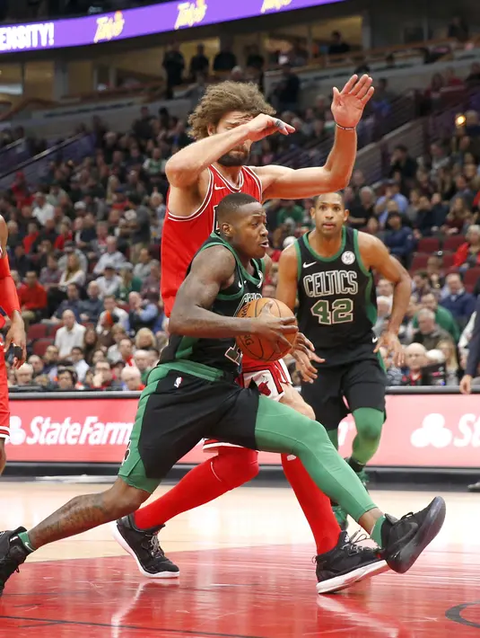 Pemain Boston Celtics, Terry Rozier berusaha melewati adangan pemain Chicago Bulls, Robin Lopez pada lanjutan NBA basketball game di United Center, Chicago, (11/12/2017). Bulls menang 108-85. (AP/Charles Rex Arbogast)