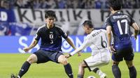 Pemain Timnas Indonesia, Beckham Putra (tengah), berupaya melewati adangan pemain Jepang, Kota Takai, pada laga pemungkas Grup C Kualifikasi Piala Dunia 2026 di Panasonic Stadium Suita, Osaka, Selasa (10/6/2025) sore WIB. (Shohei Miyano/Kyodo News via AP)