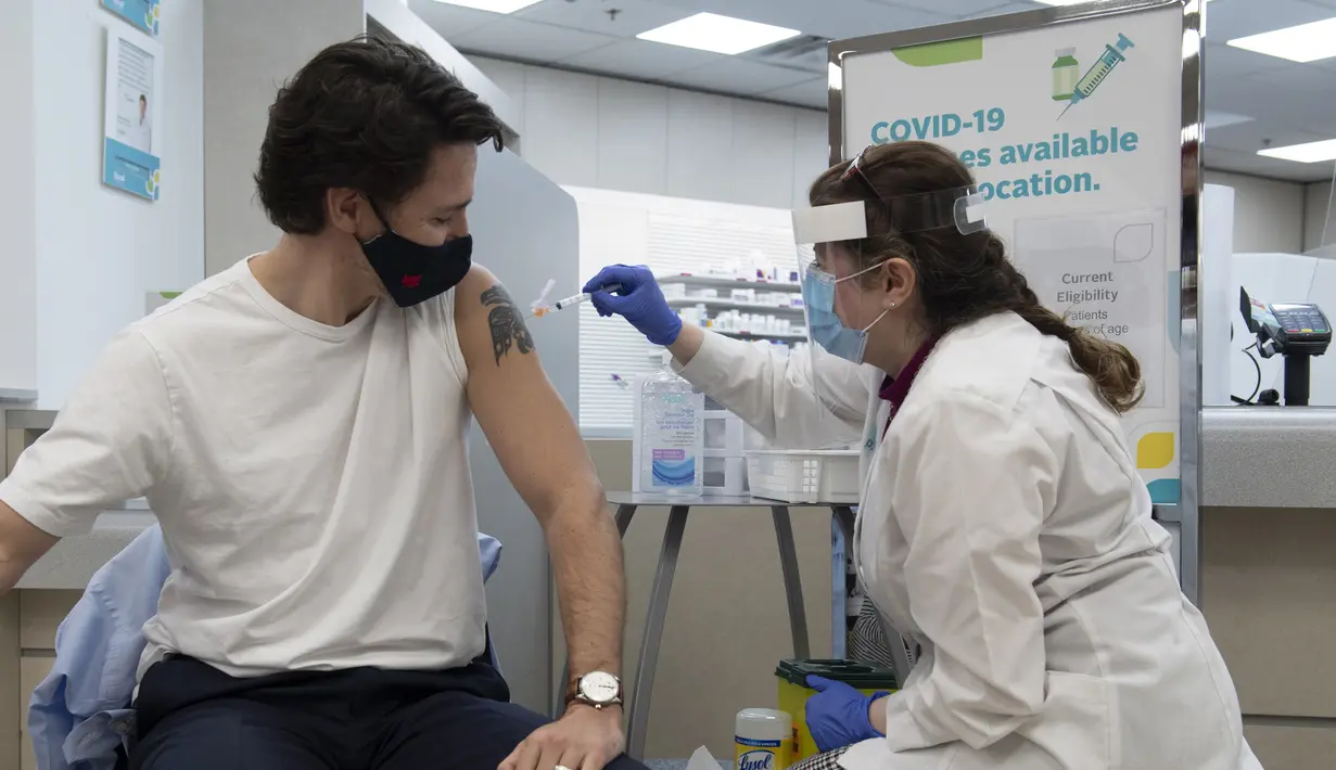 Perdana Menteri Kanada Justin Trudeau (kiri) menerima vaksinasi COVID AstraZeneca pertamanya di Ottawa, Kanada, Jumat (23/4/2021). Trudeau menerima suntikan vaksin AstraZeneca bersama istrinya, Sophie, di sebuah klinik apotek di Ottawa. (Adrian Wyld/The Canadian Press via AP)