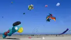 Orang-orang menerbangkan layang-layang berbagai bentuk dan warna dalam Festival Layang-Layang Internasional ke-32 di pantai Berck-sur-Mer, Prancis utara, 18 April 2018. Kegiatan internasional ini berlangsung hingga 22 April 2018. (Denis Charlet/AFP)