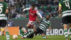 Pemain Arsenal, Reiss Nelson (tengah) berusaha melewati pemain Sporting CP pada laga leg pertama Liga Europa 2022/2023 di Jose Alvalade Stadium, Lisbon, Jumat (10/03/2023) dini hari WIB. Laga berakhir dengan skor imbang 2-2. (AP Photo/Armando Franca)