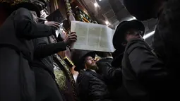 Pria ultra-Ortodoks Yahudi membaca Kitab Ester, yang menceritakan kisah festival Yahudi Purim, di sebuah sinagoga di Bnei Brak, Israel, Senin (6/3/2023).Hari raya Purim Yahudi memperingati keselamatan orang Yahudi dari genosida di Persia kuno, sebagaimana diceritakan dalam Kitab Ester. (AP Photo/Oded Balilty)