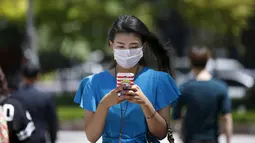 Seorang wanita beraktivitas memakai masker saat berjalan di pusat perbelanjaan Myeongdong di Seoul, Korea Selatan, Rabu (3/6/2015). Korea Selatan siaga satu menghadapi wabah virus mematikan Middle East Respiratory Syndrome (MERS). (REUTERS/Kim Hong-Ji)