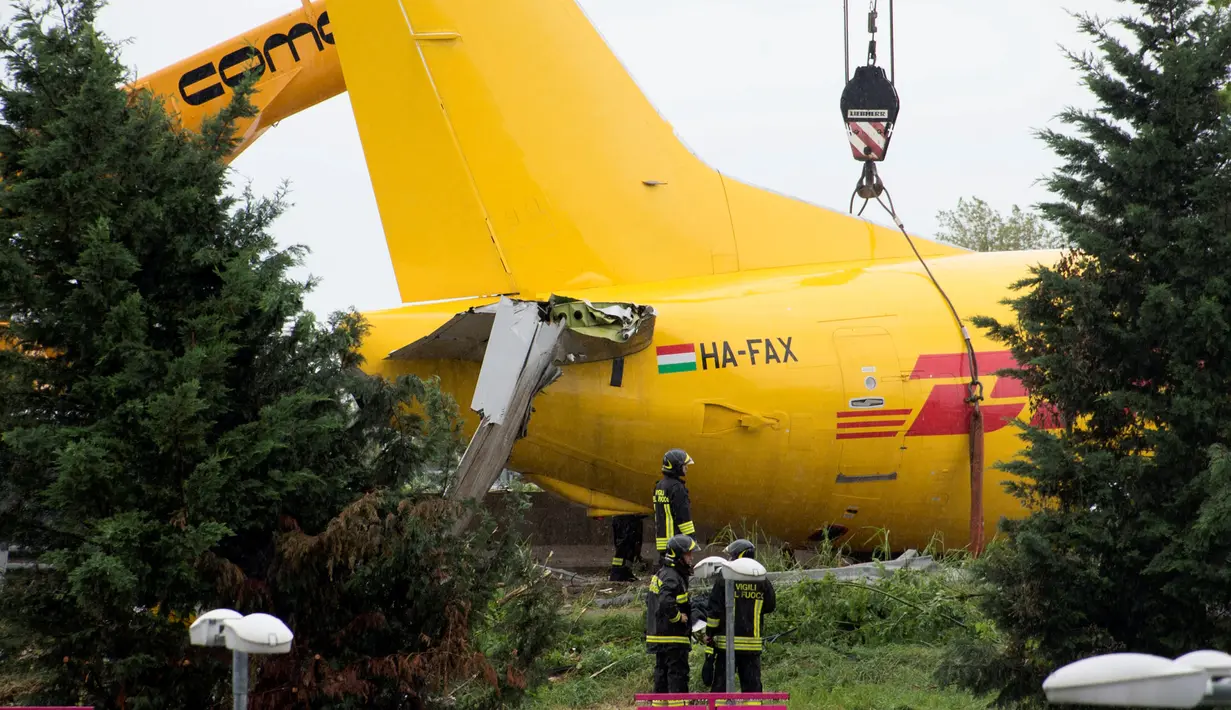 Petugas melakukan evakuasi pada pesawat kargo DHL yang tergelincir di landasan pacu di bandara Orio al Serio, Milan, Italia (5/8). Beruntung insiden ini tidak memakan korban jiwa, namun pesawat mengalami kerusakan parah. (REUTERS)