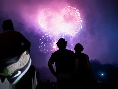 Sejumlah orang menonton kembang api saat perayaan hari kemerdekaan AS di Washington DC (4/7). Ribuan orang berkumpul untuk menyaksikan pertunjukan dan menikmati perayaan tersebut. (AFP Photo/Brendan Smialowski)