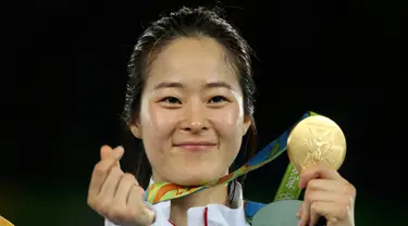 Senyum atlet Korsel, Oh Hye-Ri berpose dengan medali emasnya usai menjuarai cabang Taekwondo 67kg wanita Olimpiade 2016 di Carioca Arena 3, Rio de Janeiro, Brazil, (19/8). Atlet 28 tahun ini mengalahkan atlet Prancis Haby Niare. (REUTERS/Issei Kato) 