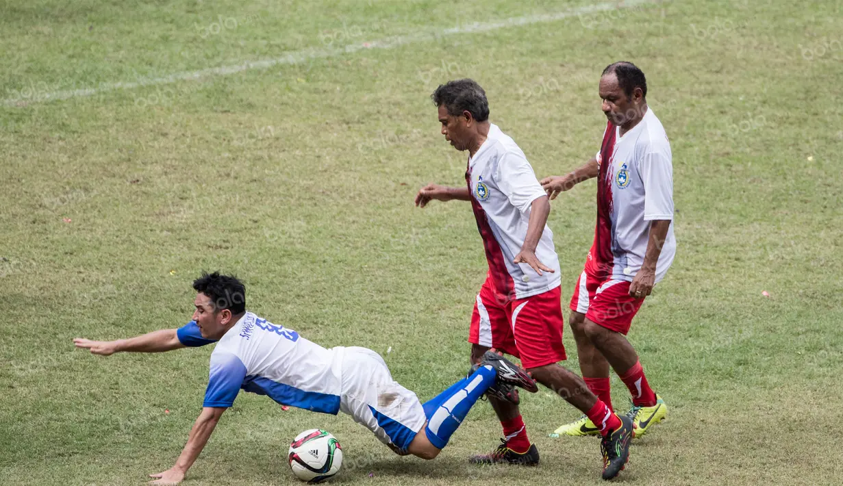 Mantan pemain Indonesia era 80an, Rully Nere (kanan), menjatuhkan pemain Siwo Jaya pada laga Agum Gumelar Cup di SUGBK, Jakarta, Minggu (10/4/2016). Rully adalah mantan bintang Persipura yang kini berusia 58 tahun. (Bola.com/Vitalis Yogi Trisna)