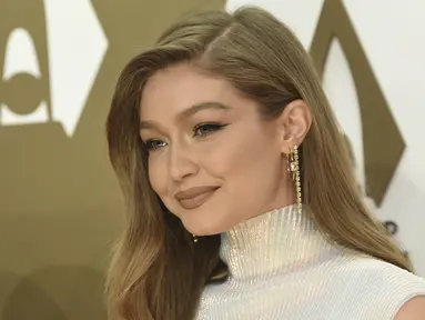 Gigi Hadid tersenyum saat tiba menghadiri CMA Awards tahunan ke-53 di Bridgestone Arena di Nashville, Tennessee (13/11/2019). Model berusia 24 tahun ini tampil memukau dalam balutan gaun putih. (AP Photo/Evan Agostini)