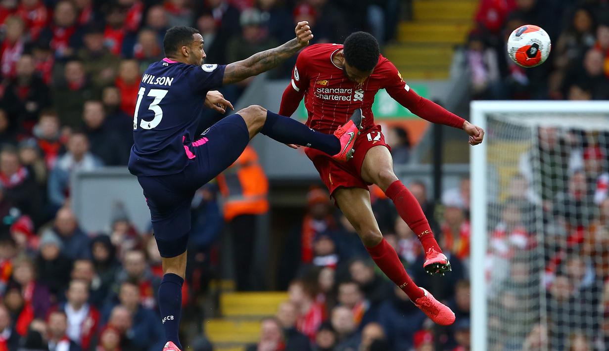 Bek Liverpool, Joe Gomez, berebut bola dengan pemain Bournemouth pada laga lanjutan Premier League 2019-2020 di Anfield, Liverpool, Sabtu (7/3) malam WIB. Liverpool menang 2-1 atas Bournemouth. (AFP/Geoff Caddick)