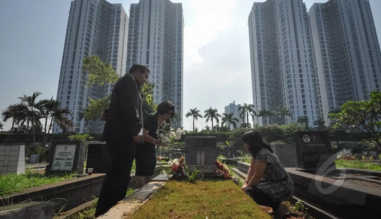 Umat Kristiani tampak berdoa sembari membersihkan makam keluarga dan kerabatnya pada momen Paskah di Menteng Pulo, Jakarta, Minggu (5/4/2015). (Liputan6.com/Faizal Fanani)