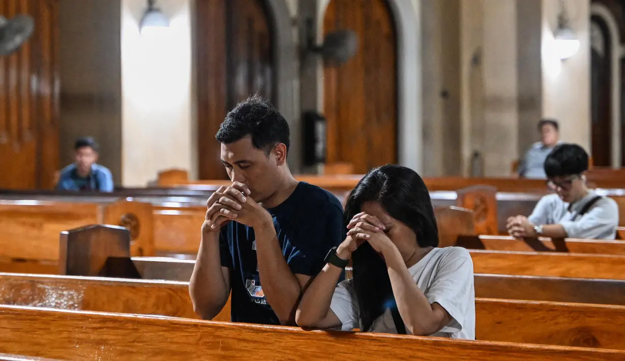 Umat Katolik berdoa setelah misa di Gereja Baclaran di Paranaque, Metro Manila, Filipina pada 21 April 2025, menyusul wafatnya Paus Fransiskus di Vatikan. (Jam STA ROSA/AFP)