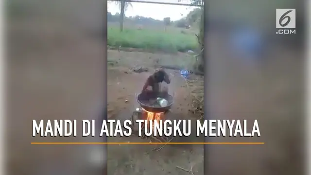 Seorang bocah nekat mandi di wajan besar di atas tungku api yang menyala,