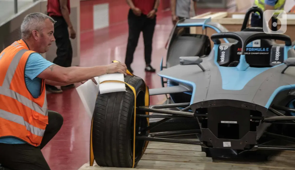 Panitia membuka kemasan replika mobil Formula E untuk kali pertama di Stadion Balap Sepeda Velodrome, Rawamangun, Jakarta Timur, pada Kamis (26/5/2022). Ini merupakan replika salah satu mobil Formula E yang akan mengaspal di Sirkuit Ancol pada 4 Juni mendatang. (Liputan6.com/Faizal Fanani)