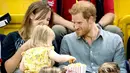 Pangeran Harry membuat wajah menggemaskan saat seorang anak mencuri popcornnya di Invictus Games, 2017. (Samir Hussein/WireImage)