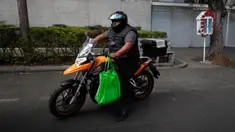 Seorang pria yang mengendarai sepeda motor membawa bahan makanan dalam tas yang dapat digunakan kembali di Mexico City pada1 Januari 2020. Berdasarkan undang-undang baru yang berlaku, pasar swalayan akan didenda jika memberi kantong plastik kepada pelanggan mereka. (AP/Rebecca Blackwell)