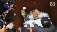 Seorang pria melakukan azan saat pemakaman Vanessa Angel dan Bibi Andriansya di Taman Makam Islami Malaka, Pesanggrahan, Jakarta, Jumat (5/11/2021). Vanessa Angel dan Bibi Andriansyah meninggal dalam kecelakaan lalu lintas di Tol Mojokerto-Jombang pada 4 November 2021. (Liputan6.com/Herman Zakharia)