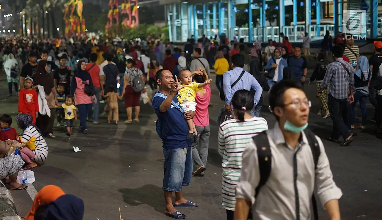 Warga memadati Jalan MH Thamrin saat ada malam puncak peringatan HUT DKI Jakarta ke-492 di Bundaran HI Jakarta, Sabtu, (22/6/2019). Peringatan HUT Jakarta dibuka Gubernur DKI Jakarta Anies Baswedan. (Liputan6.com/Immanuel Antonius)