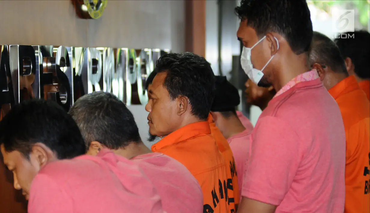 Tersangka penyebar hoax diperlihatkan petugas Dittipid Siber Bareskrim Polri saat rilis di Jakarta, Rabu (21/2). 18 tersangka yang ditahan, 8 dari Jabar, 4 Jakarta, 1 Banten, 1 Bandung, 1 Lampung, 1 Jaktim, dan 2 Sumut. (Liputan6.com/Helmi Fithriansyah)
