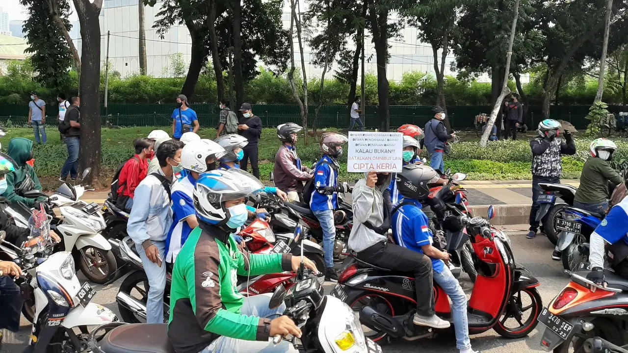 Rombongan buruh yang demo melintas di Jalan Gatot Subroto, Jakarta.