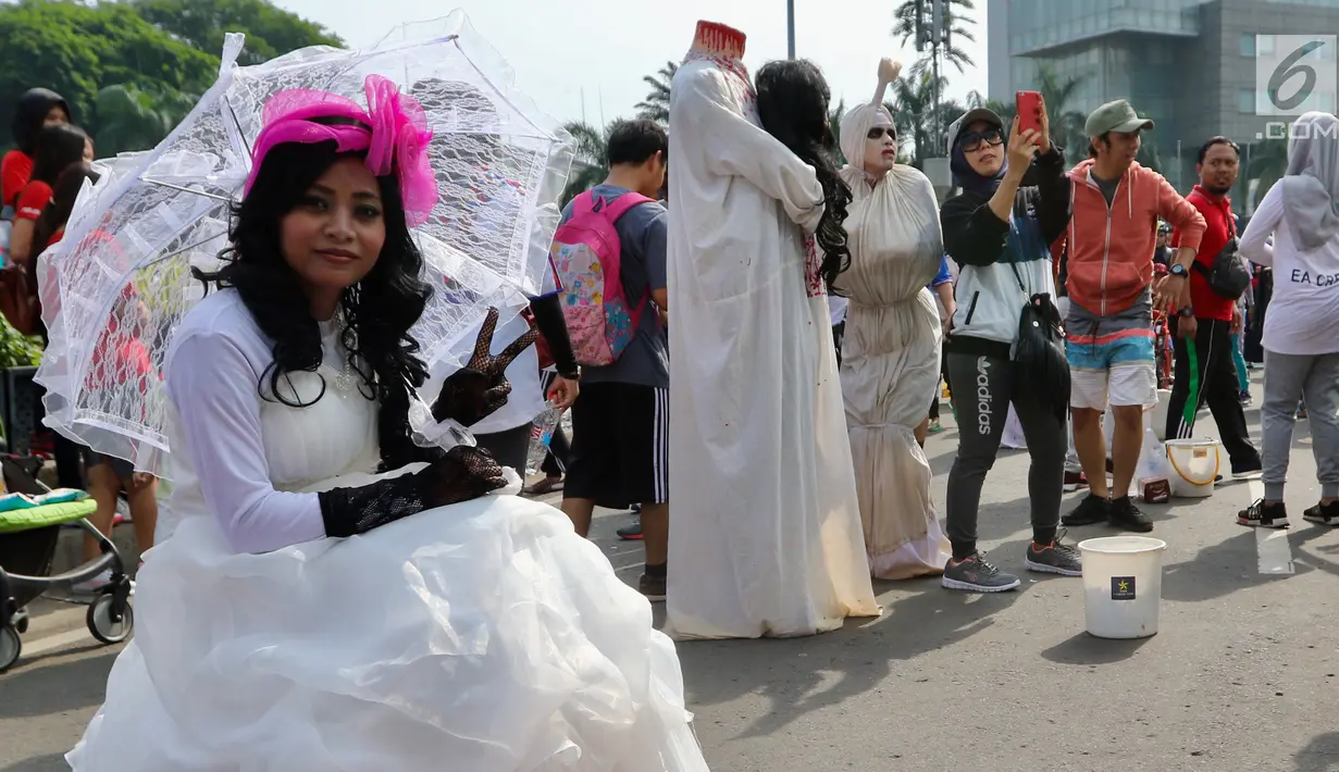 Seniman dengan kostum none Belanda berpose saat kegiatan Car Free Day di Bundaran HI di Jakarta, Minggu, (12/11). Mereka membuka kesempatan kepada warga yang ingin foto bersama. (Liputan6.com/Fery Pradolo)