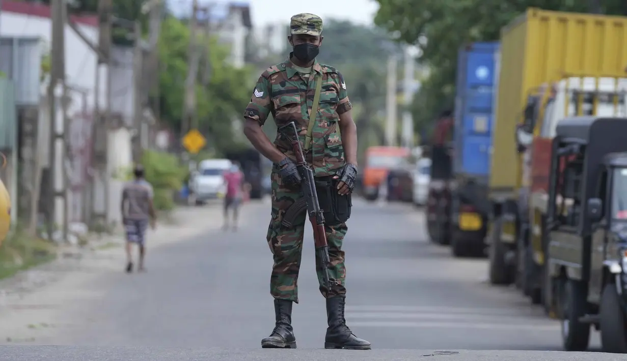 Seorang tentara Sri Lanka berjaga-jaga di sebuah jalan selama jam malam di Kolombo, Minggu (3/4/2022). Anggota parlemen oposisi berkumpul memprotes langkah presiden memberlakukan jam malam dan keadaan darurat di tengah memburuknya situasi krisis ekonomi. (AP Photo/Eranga Jayawardena)