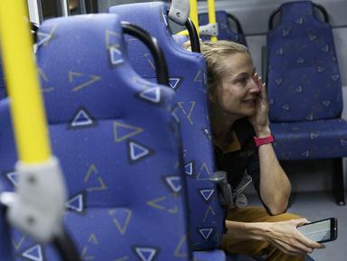 Seorang wartawan menangis ketakutan saat sebuah bus yang mengangkut sejumlah jurnalis di Olimpiade Rio 2016 terkena peluru nyasar pada Selasa (9/8/2016) malam waktu Brasil. (Reuters/Shannon Stapleton)