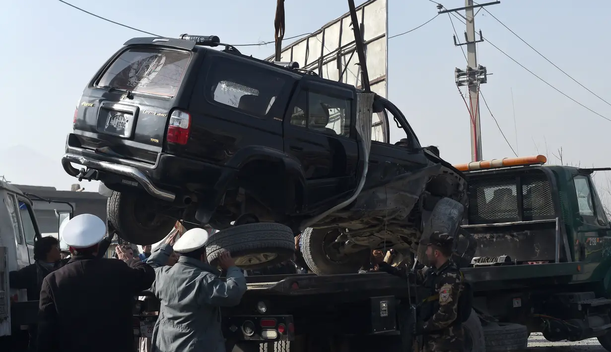 Petugas mengevakuasi bangkai mobil anggota parlemen Afghanistan yang rusak akibat ledakan bom di jalanan Ibu Kota Kabul, Rabu (28/12). Belum ada kelompok maupun pihak tertentu yang mengklaim bertanggung jawab atas ledakan bom ini. (WAKIL KOHSAR/AFP)
